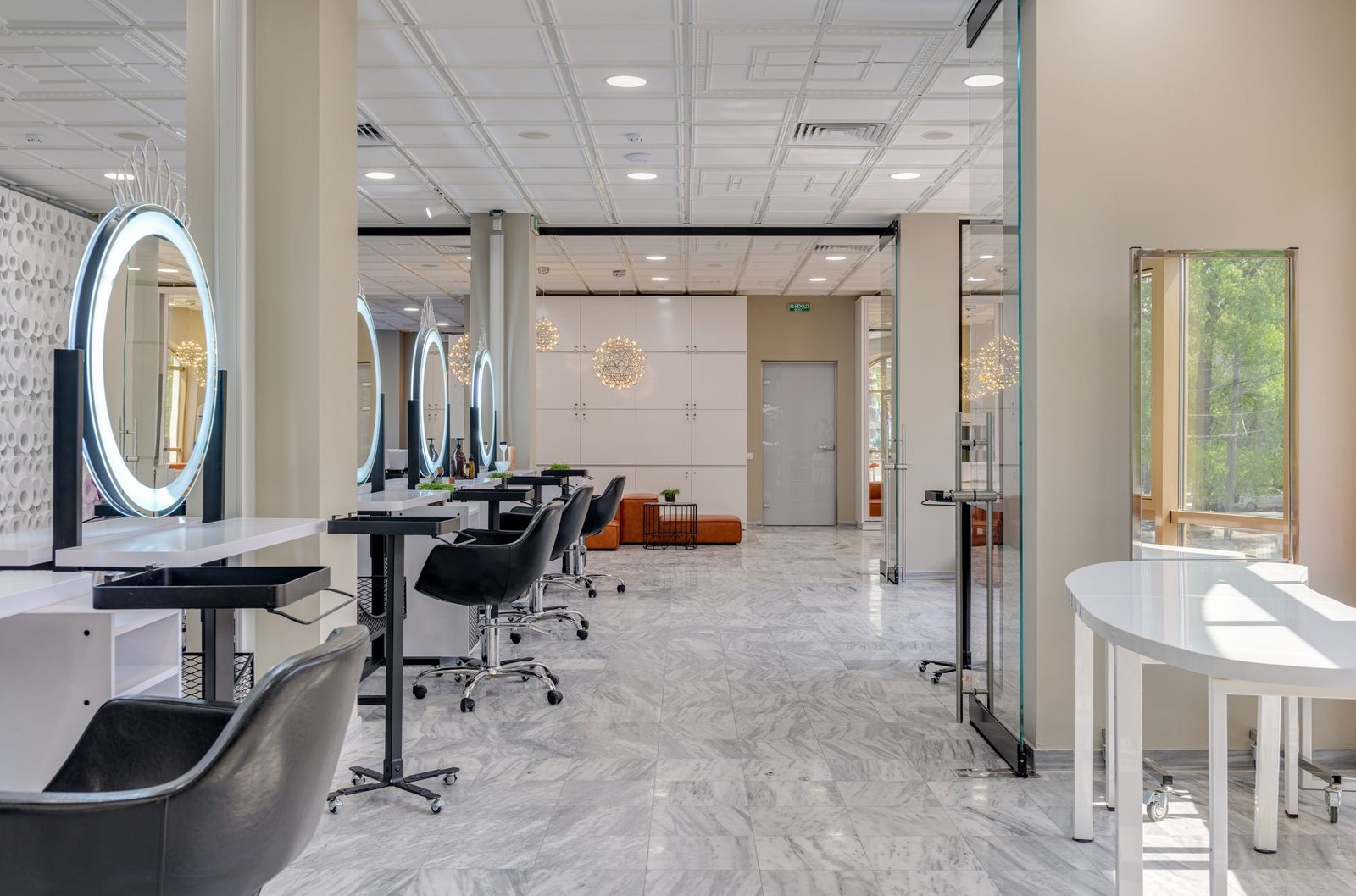 Elegant private salon suite row with illuminated round mirrors and marble flooring
