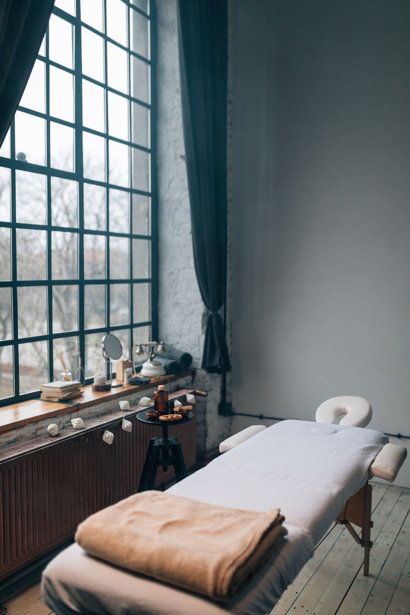 Private massage suite with a loft window and warm natural light