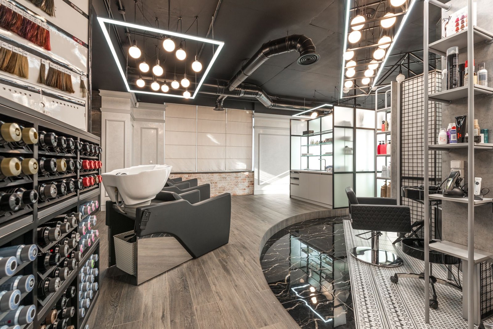 Dramatic modern salon interior with a curved washing station and geometric lighting